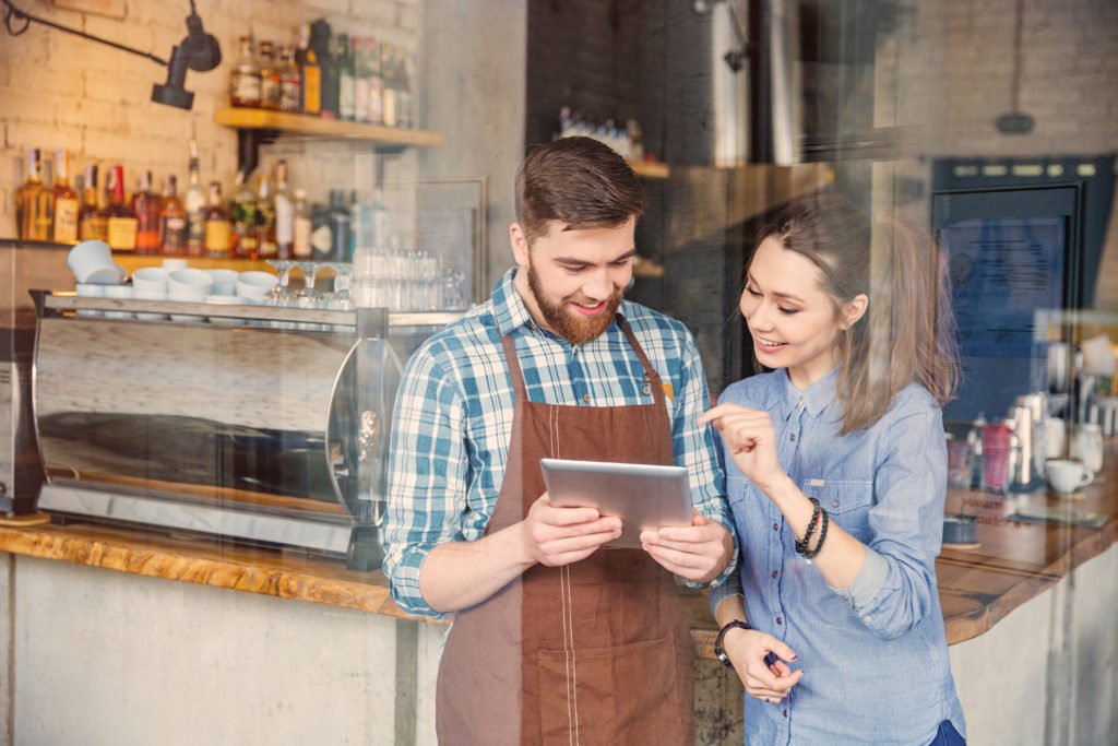 Two people watch a video in a coffee bar